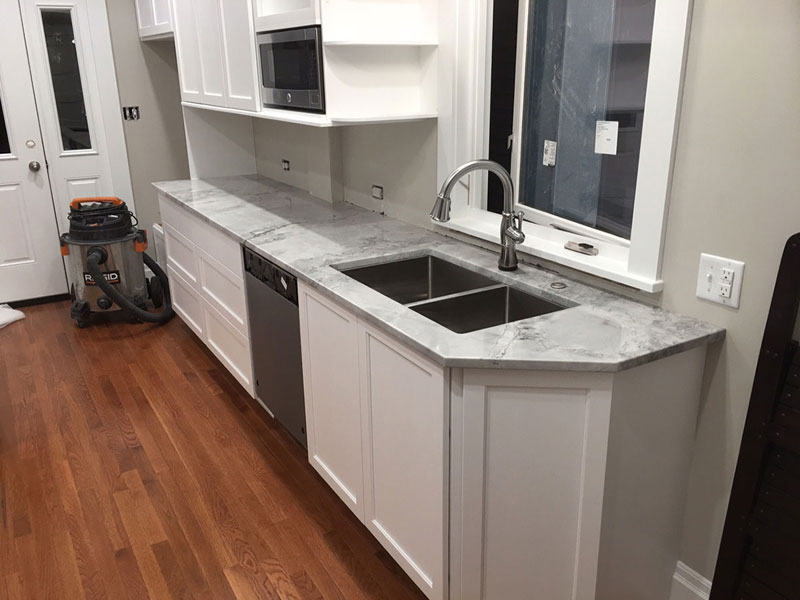 Kitchen With White Cabinets And Super White Granite Countertops
