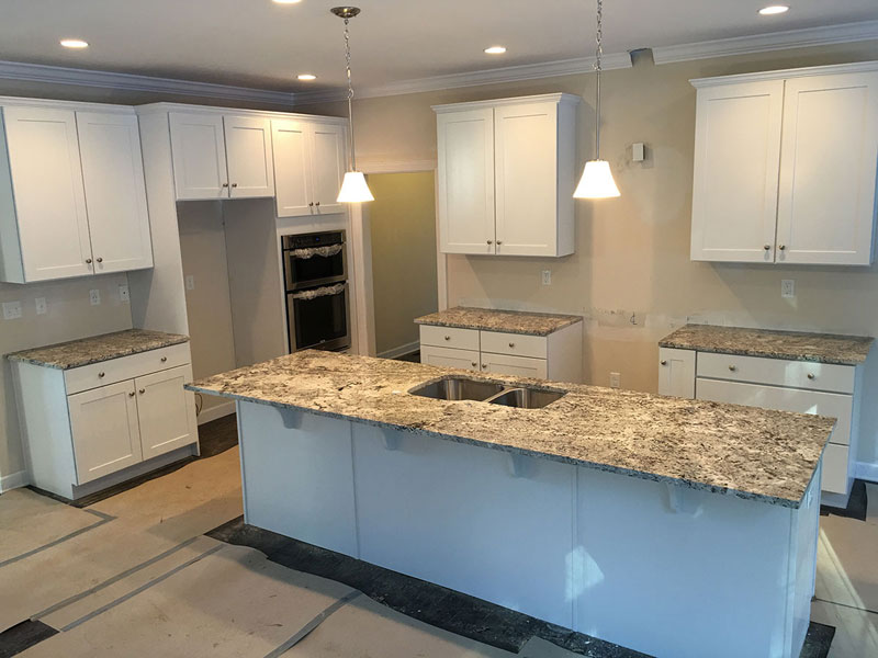 Kitchen With White Cabinets And Alaska White Granite Countertops