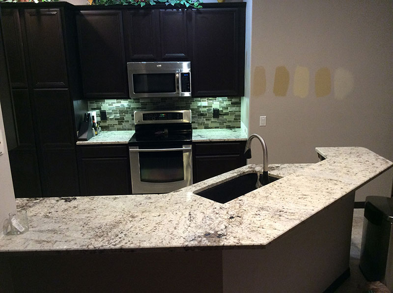 Kitchen With Black Cabinets And White Galaxy Granite Countertops