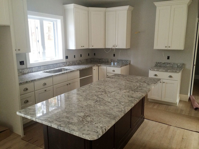 Kitchen With White Cabinets And Thunder White Granite Countertops